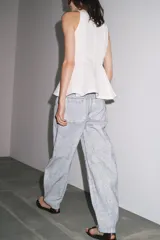 Pantalón de jean de tiro medio con pierna ancha y corte tapered, confeccionado en tejido de algodón revestido color gris claro. Cuenta con bolsillos delanteros y traseros, trabillas en la cintura y cierre frontal con cremallera y botón.