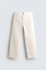 Pantalón chino negro de corte relajado (relaxed fit) con tiro medio, confeccionado en algodón con elasticidad. Presenta bolsillos delanteros y bolsillos traseros de vivo, con cierre frontal de cremallera y botón.