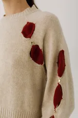 Sweater color gris claro con cuello redondo, mangas largas acampanadas y aberturas circulares en hombros y mangas con detalles de tela blanca.