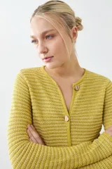 Chaqueta tejida roja con botones metálicos dorados y cuello redondo.