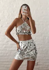 Top plateado de lentejuelas con cuello halter y espalda descubierta.