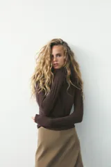 Falda pantalón color beige de tiro medio con diseño asimétrico.