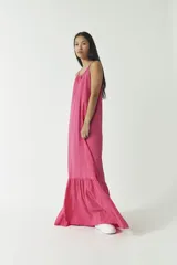 Vestido largo fucsia con breteles finos y escote en V. Presenta un corte a la altura de las rodillas con volados.