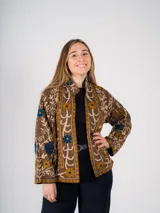 Chaqueta marrón con bordados florales en tonos azul y amarillo.