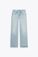 Pantalón de jean celeste claro, de tiro bajo, corte wide leg y largo hasta el tobillo. Tiene cinco bolsillos, cierre frontal con cremallera y botón metálico.