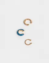 Set de tres earcuffs dorados, uno esmaltado en azul y otro con diseño torzado.