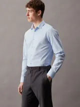 Camisa celeste de popelín de algodón elástico, corte slim, manga larga y cierre frontal con botones.
