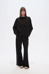 Buzo negro con capucha, cuello alto con broches, manga larga y bolsillo canguro frontal.