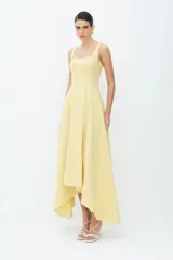 Vestido midi blanco de algodón compacto con corte entallado y bajo ancho. Presenta cortes asimétricos en el bajo, escote recto, cremallera de nailon en la espalda y tirantes anchos.