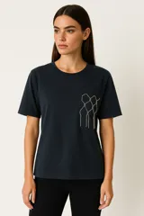 Remera de manga corta color azul marino, con cuello redondo y bolsillo en el pecho con apliques de strass formando un diseño geométrico.