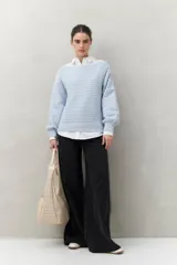 Sweater negro tramado de silueta relajada, con combinación de texturas en el tejido y mangas abullonadas con puños elastizados.