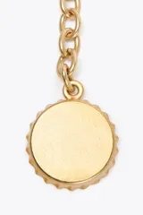 Charm para bolso con cuerda anudada color marrón y abalorios metálicos dorados.
