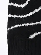Gorro de lana blanco con diseño de líneas onduladas color dorado y pompón blanco en la parte superior.
