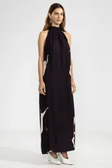 Vestido largo negro con estampado de sirenas color crema, cuello halter y corte evasé.