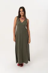 Vestido largo verde militar con escote en V, sin mangas y tajos laterales.