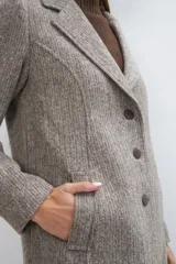 Tapado corto entallado color marrón claro con textura de espiga, cuello solapa y manga larga. Cierre frontal con botones.