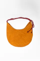 Bolso bandolera marrón con forma de media luna y asa de cuerda trenzada en tonos rojo y beige.