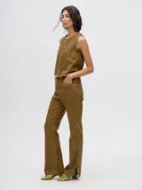 Pantalón de jean azul de tiro alto y corte oxford con apliques metálicos en bolsillos y laterales.