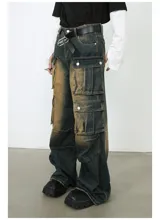 Pantalón de jean ancho (baggy) con lavado oscuro y efecto desgastado en tonos marrones/ocre. Presenta múltiples bolsillos cargo grandes con tapa y botones a presión en las piernas.