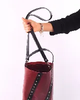 Bolso matero color bordó, de cuero, con doble asa (una de mano y otra larga desmontable), divisor interno para termo y mate, y bolsillo interior.