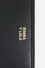 Billetera negra de piel reconstituida con estructura rígida, cierre con cremallera dorada, tirador de cordón y logo metálico Bimba y Lola. Cuenta con bolsillo interior con cremallera e interior con logo grabado.