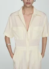 Mono color crema de manga corta, con cuello camisero, cierre frontal con botones, dos bolsillos de parche en el pecho, dos bolsillos laterales y dos bolsillos cargo.