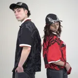 Gorra de béisbol negra con visera curva y bordado frontal en blanco y gris claro con diseño de llamas estilizadas.