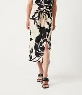 Pollera midi color beige con estampado floral negro, lazo en la cintura y tajo lateral.