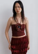 Top strapless color borgoña con tiras finas para atar al cuello y flor de lino con mostacillas en el escote.