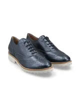 Zapato Oxford color bronce con detalles de perforaciones y suela blanca de goma.