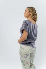 Blusa gris lavanda metálico de corte recto y fluido, con mangas cortas con vuelta, escote redondo y abertura en la espalda.