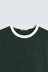 Camiseta azul marino de corte regular, cuello redondo y manga corta con ribete blanco en cuello y mangas.