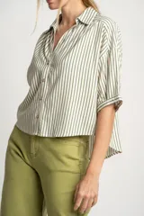 Camisa oversize a rayas verticales color verde y blanco, con cuello clásico, manga corta y cierre frontal con botones.