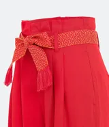 Pantalón acampanado de lino color celeste, con bolsillos, cinturón bordado y pliegues delanteros.