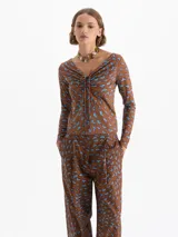 Top de punto color rojo con estampado de labios en azul y fucsia. Presenta escote en V profundo con jareta ajustable para anudar, mangas largas y calce al cuerpo.