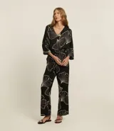 Blusa negra con estampado de hojas en color crema, escote en V y mangas 7/8.