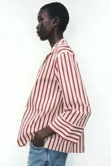Camisa de manga larga con cuello solapa y cierre frontal con botones. Diseño a rayas verticales color borgoña y crema.