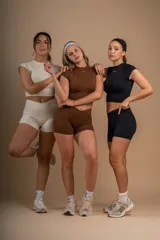 Conjunto deportivo color crema compuesto por un top corto de mangas cortas y unos shorts de tiro alto.