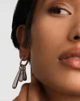 Aro individual de plata con colgante en forma de gota.