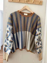 Sweater tejido con hilo de algodón y lurex, con diseño de rayas y flores, cuello redondo, mangas abullonadas y silueta oversize.