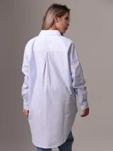 Camisa celeste y blanca a rayas verticales, de corte amplio y mangas largas.