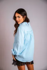 Camisa color beige de muselina con bordado en la parte delantera y manga globo con puño.