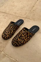 Slippers con estampado animal print, forro y plantilla de cuero negro.