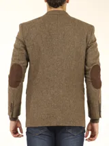 Blazer marrón corte slim, confeccionado en tejido con mezcla de lana. Cuello con solapas, manga larga con puño abotonado, bolsillos de solapas en cadera, abertura en espalda, cierre frontal de botonadura y coderas en suede chocolate.