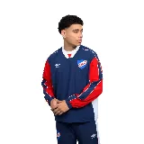 Buzo de entrenamiento del Club Nacional de Football, marca Umbro. Diseño azul con mangas rojas y detalles blancos. Incluye logo de Umbro y escudo del club en el pecho.