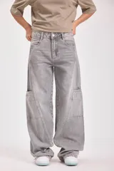 Pantalón de jean gris de corte ancho con bolsillos laterales y pañuelo estampado atado a la cintura.