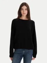 Sweater negro de calce relajado con cuello redondo y mangas largas, con terminaciones acanaladas en puños y ruedo.