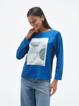 Blusa azul con estampado geométrico en blanco y negro, de mangas largas y cuello redondo.