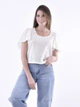 Blusa color crema con mangas abullonadas y diseño con pequeños puntos en relieve.