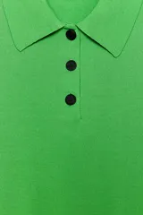 Top azul eléctrico de punto, con cuello polo, manga corta y cierre frontal con botones negros.